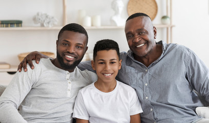 Handsome Senior African Man Embracing His Son And Grandson At Home