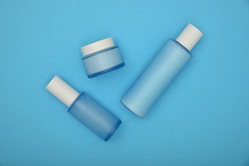 Set of cosmetic skin care cream bottles on blue