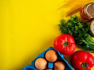Food supplies on yellow background, top view with copy space