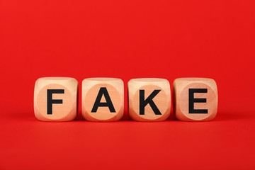 Wooden cubes with FAKE word over red