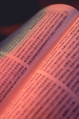 Libro de la biblia escrito en chino con una luz que colorea el libro.
