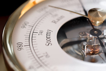 close up of the word Stormy in an analog barometer, including a detail of the barometer mechanism