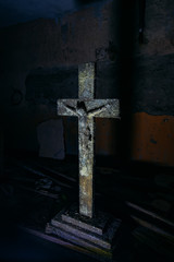 Old rotten wooden statue of crucified Jesus Christ in dark room