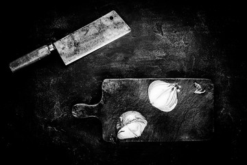 Meat Cleaver and Cutting Board on Dark Background in Black and White. Butcher Shop Tools Concept.