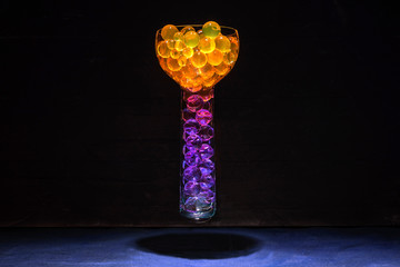 A vase with colored gel balls floats in the air above the table.