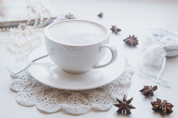 Obraz na płótnie Canvas Cofee cup with memories block-note on white dresser scarf