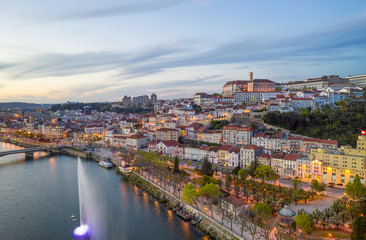 Fototapeta na wymiar Coimbra drone aerial city view at sunset with colorful fountain in Mondego river and beautiful historic buildings, in Portugal