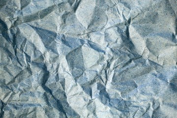Obraz premium Crumpled gray paper background. Messy wrinkled parchment top view. Wrapping Vintage blue paper texture, craft sheet, old card.