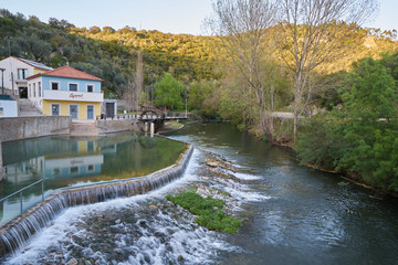 Fototapeta na wymiar Agroal river fluvial beach with a waterfall and water mill in Portugal