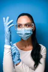 Young girl in eyeglasses, in a medical mask and gloves