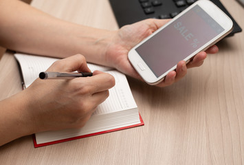 order a discount via phone, record in a notebook, write down with a pen, watch advertising