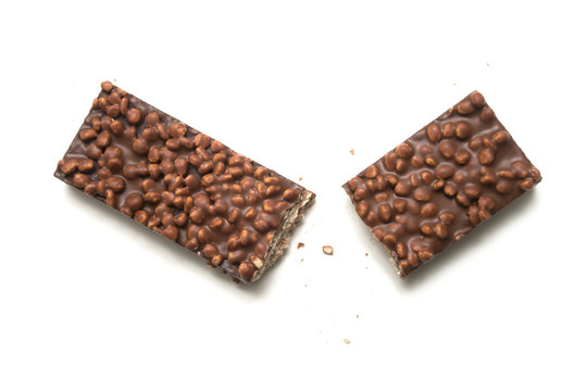 Closeup of broken chocolate bar with puffed rice on white background