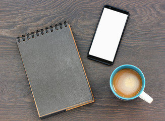blank paper notebook with a black page, smartphone with a readable screen.