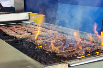 Meat patties are grilled. Outdoor picnic. Grilled burgers. Grill.