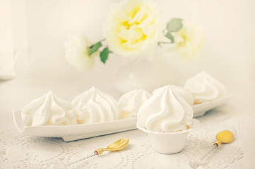 Fototapeta na wymiar White handmade meringue on a white plate is served in an elegant style. Homemade cake