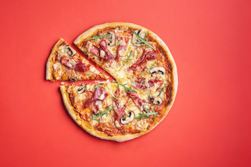 Ham pizza homemade. Pizza top view on a red background.