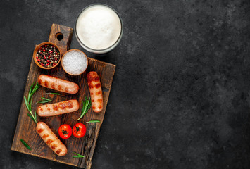 Beer and classic grilled sausages with spices on a stone background with copy space for your text