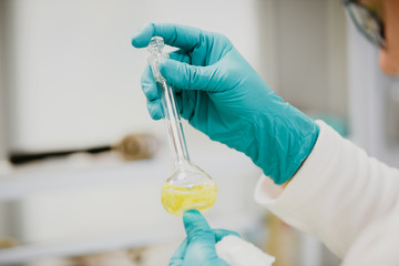 Equipment and science experiments oil pouring scientist, chemist with test tube yellow making research in the laboratory