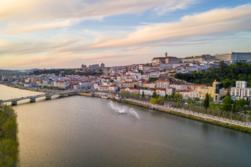 Coimbra drone aerial city view at sunset with Mondego river and beautiful historic buildings, in Portugal