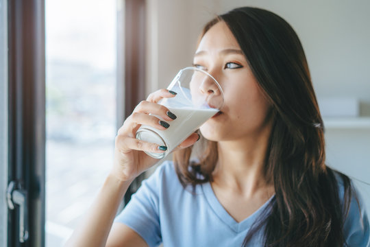 Close up view of asian woman drinking milk.