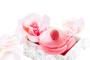 Fototapeta na wymiar Raspberry and strawberry pink macaroons on the bed decor Valentine and pink flowers isolated Delicate macaroons on the table on a white background