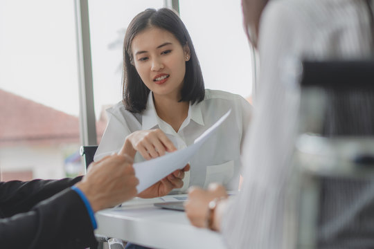 finance consultancy business concept.  Happy young female financial advisor talking to client and showing report paper of funds investment to customer.