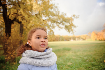 Angry little mixed girl portrait outdoors.