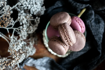 Chocolate macaroni with pieces of white and dark chocolate on an old wooden table. Close up.