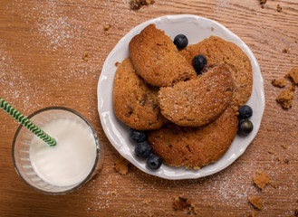caramel dulce de leche biscuits with glass of milk on wooden table 