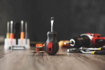 a small screwdriver set among the tools on a wooden table