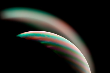 Psychedelic abstract planet from soap bubble, Light refraction on a soap bubble, Macro Close Up in soap bubble. Rainbow colors on a black background. Model of Space or planets universe cosmic galaxy.