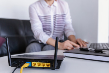 Wireless router and woman using a laptop in office. router wireless broadband home laptop computer...