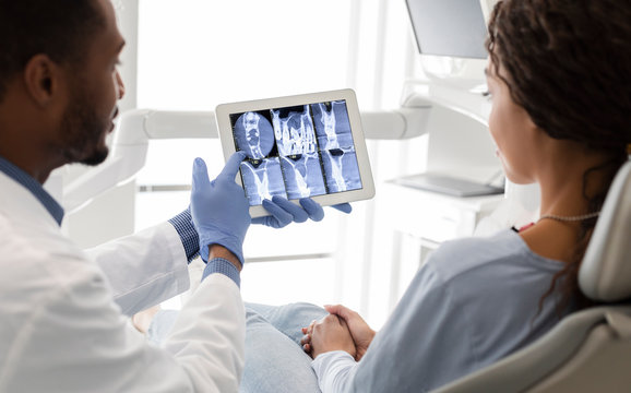 Dentist and patient looking at xray picture on digital screen