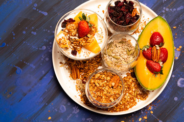 Melon pieces, on blue table with blue plate and seeds.
