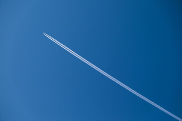 the plane is high in the sky and the trace of the plane