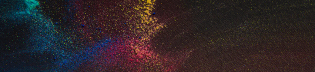 Bright powder colors scattered on black background