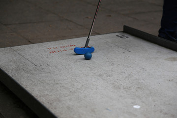 Detail Aufnahme vom Minigolf im Sommer mit einem blauen Ball auf Grauen Untergrund	
