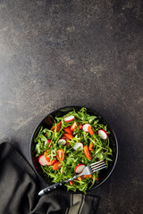 Fresh arugula salad with radishes, tomatoes and red peppers.