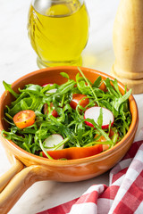 Fresh arugula salad with radishes, tomatoes and red peppers.