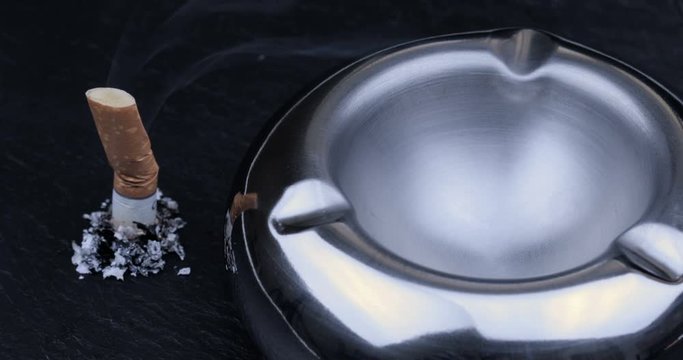 Stubbed cigarette butt stub with ash on black background