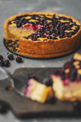 Blueberry cheesecake, tart with blueberries and black currants, dessert on a gray background