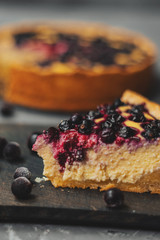 Blueberry cheesecake, tart with blueberries and black currants, dessert on a gray background