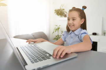 cheerfully cute girl children excited using computer learning schoolwork. kid enjoy e-learning in holiday at home.
