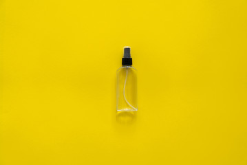 Bottle of antiseptic, a bottle of hand sanitizer, hand sanitizer spray on a yellow background, for the prevention of coronavirus. Bottle of antiseptic spray mockup, copy space for design.