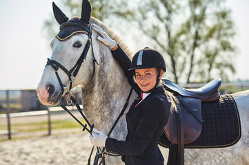 Girl horse rider stroking a horse. Equestrian theme