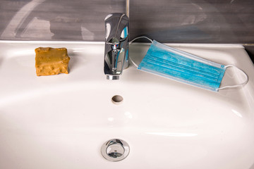 Face mask with soap at a wash basin
