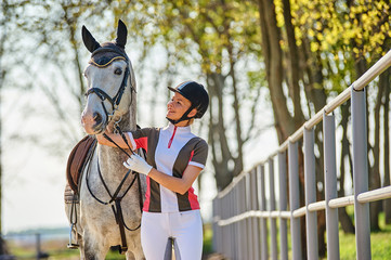 Girl horse rider stroking a horse. Equestrian theme