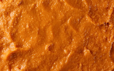 Tomato flavored hummus surface, background and texture