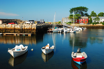 Fototapeta na wymiar Boats rest in a calm harbor at Rockport, Massachusetts