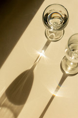 Top view of two glass wine glasses casting shadows and sunlight. Concept of wine making and wine tasting
